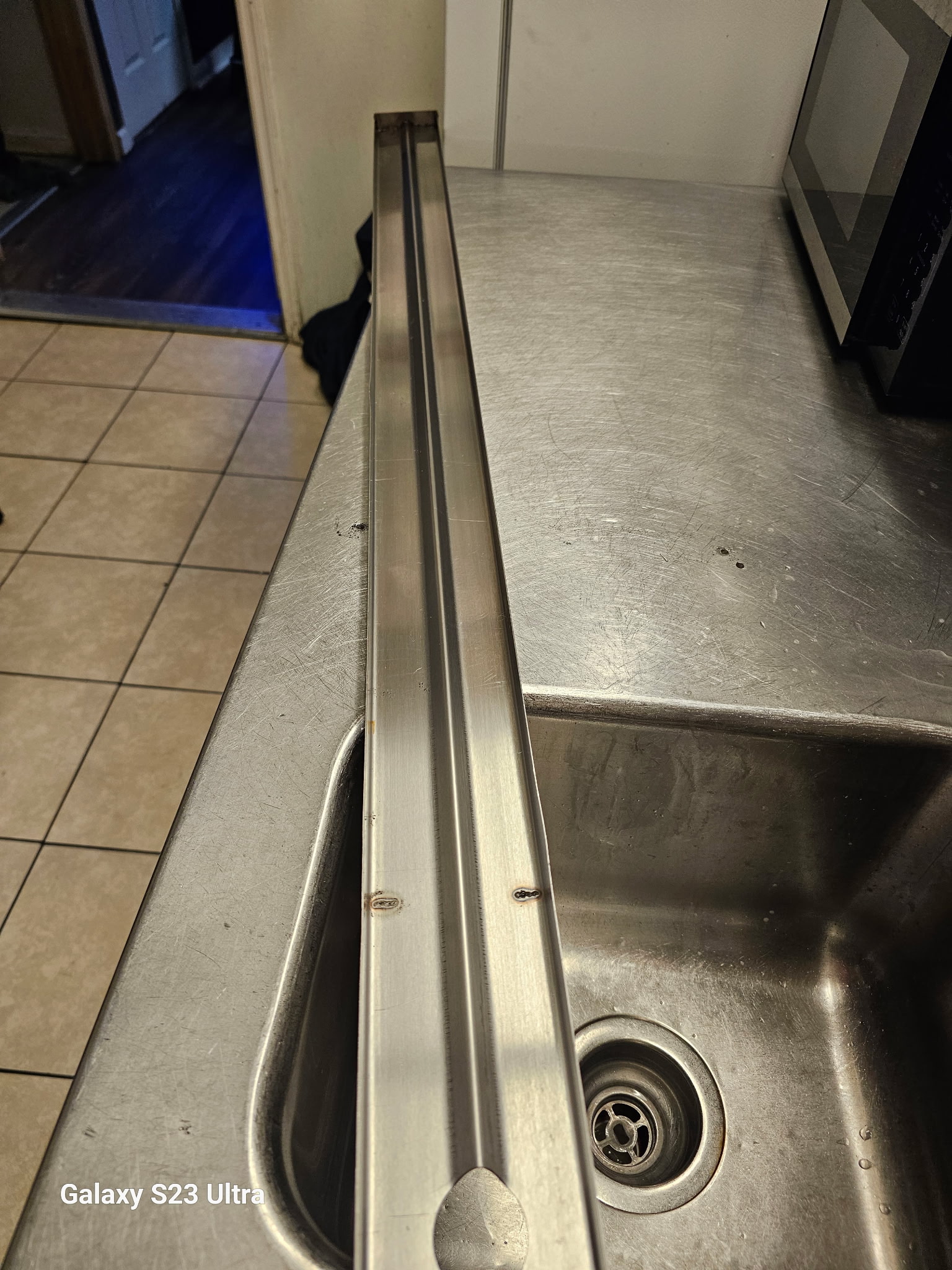 Clean stainless steel commercial kitchen sink and counters
