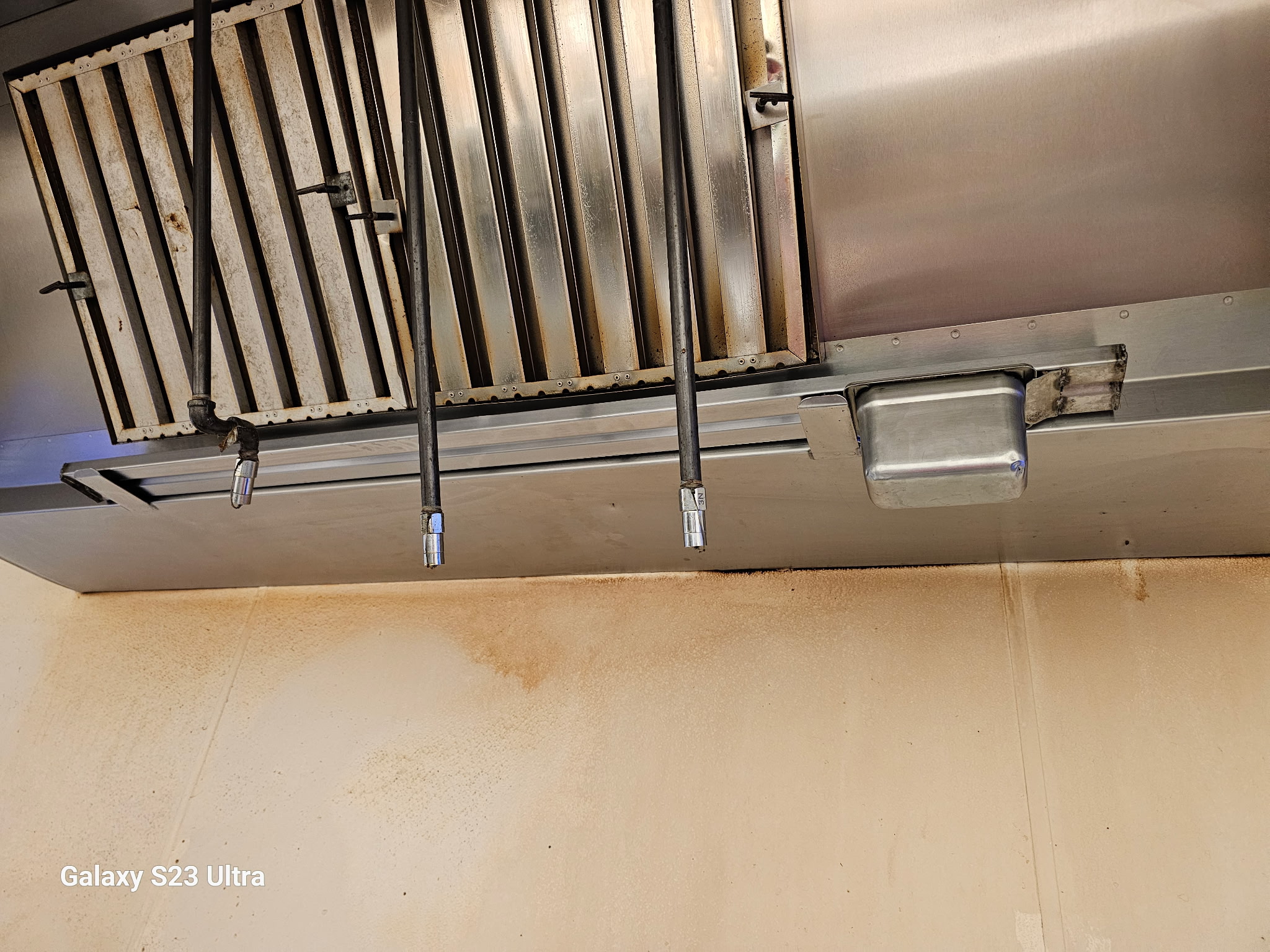 Commercial kitchen exhaust hood with fire suppression nozzles